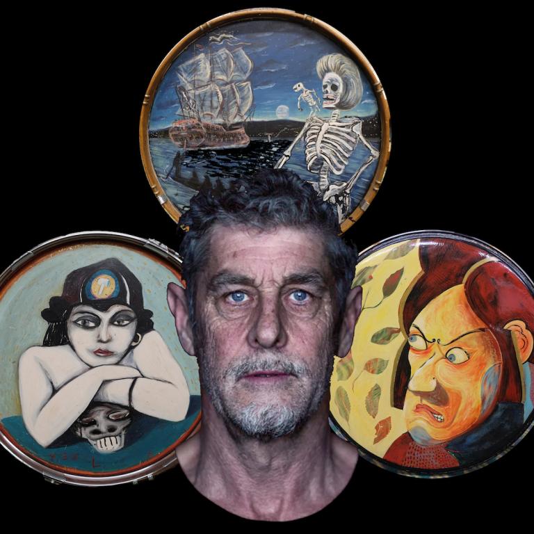 A cropped photo of Anthony Donaldson's face, behind him three of his drumkits each with painted artwork