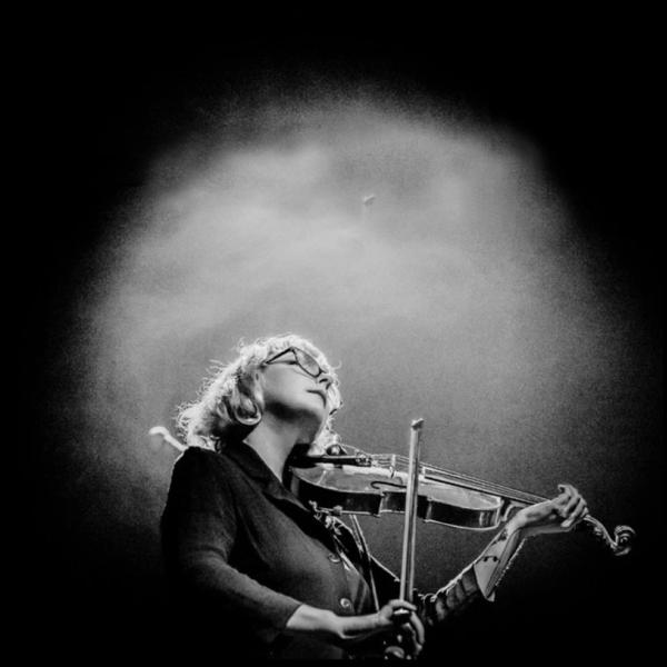 black and white vignetted photo of Motte playing violin