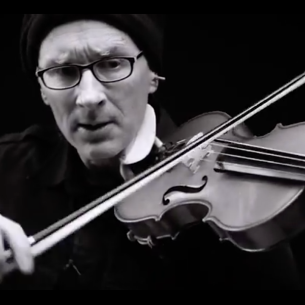 A black and white photo close-up of Chris Prosser playing the violin