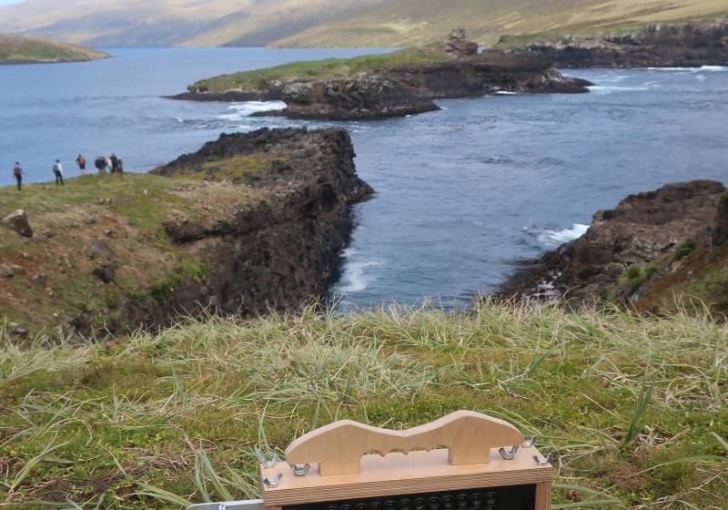 A photo of a homemade wooden analogue video camera, on a hill on a subantarctic islands, looking over the ocean