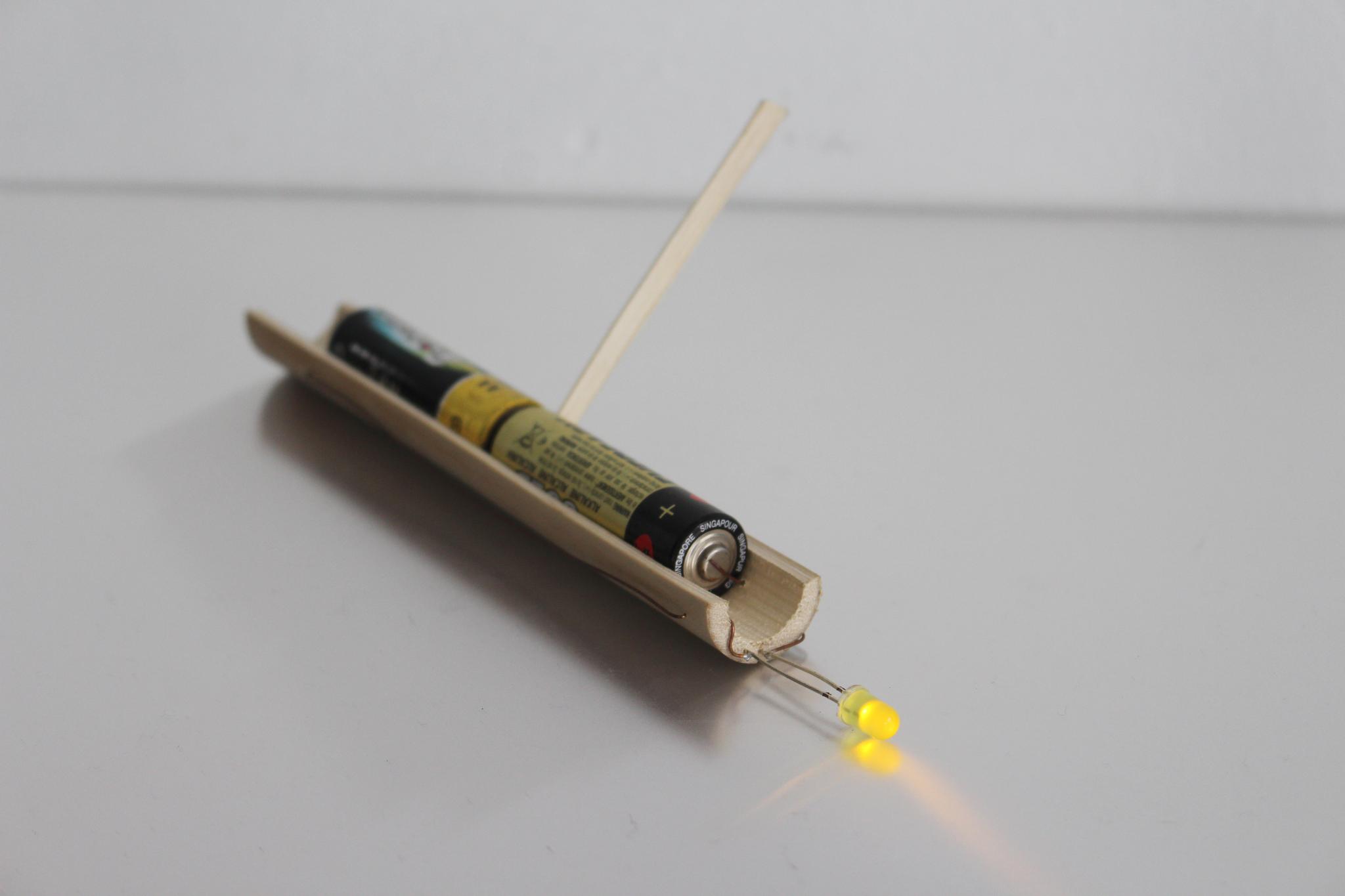 Lamp 02: Bamboo battery holder cradle, yellow LED, Copper wire, flat AA batteries.