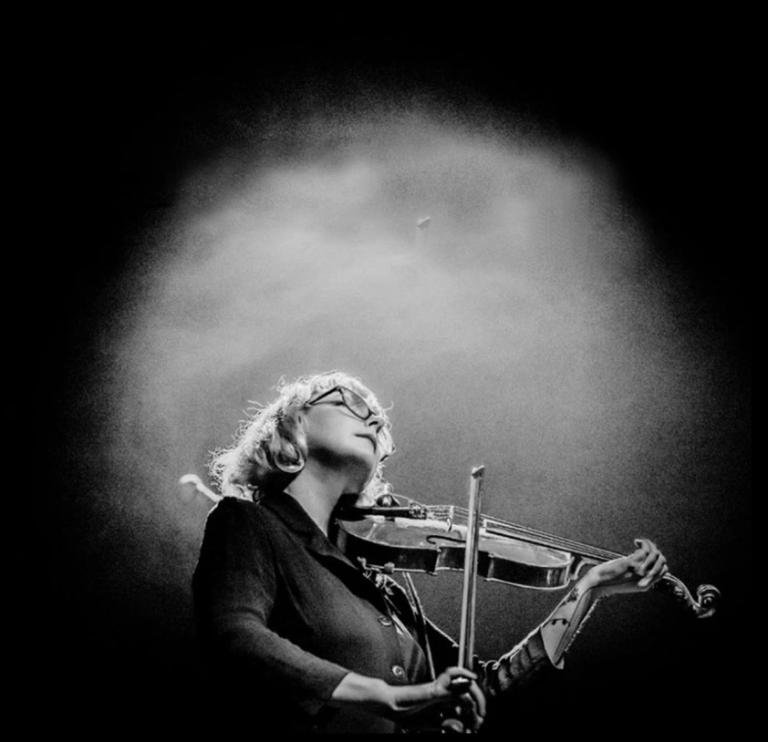 black and white vignetted photo of Motte playing violin