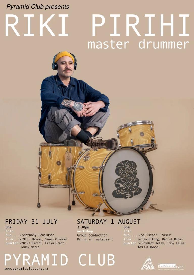Riki Pirihi sits on a yellow drumkit with a blank background