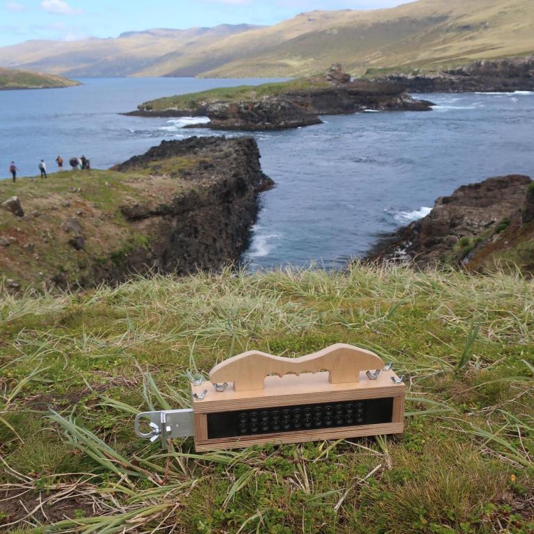 A photo of a homemade wooden analogue video camera, on a hill on a subantarctic islands, looking over the ocean